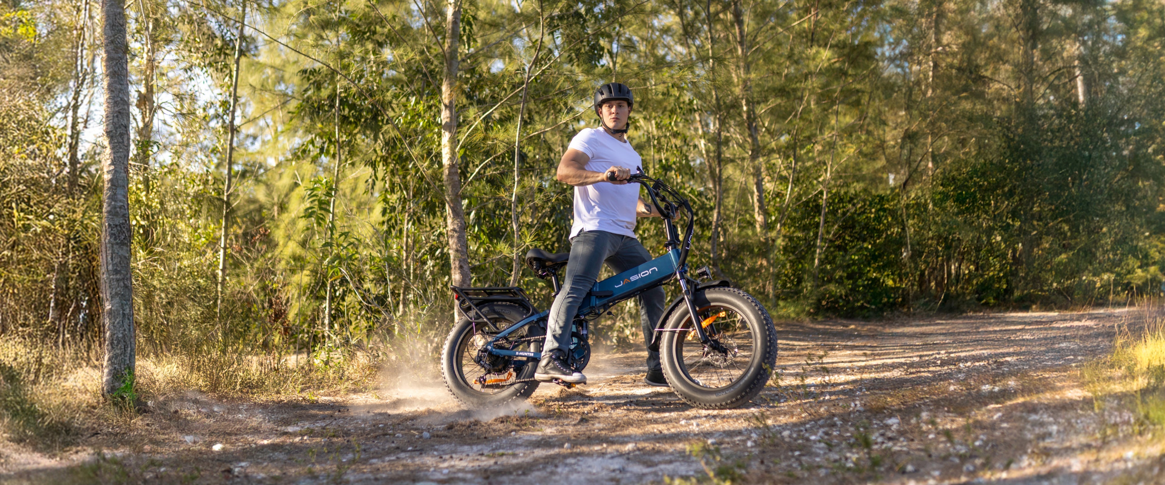 Rider on a JasionBike electric bike in a sunny forest.